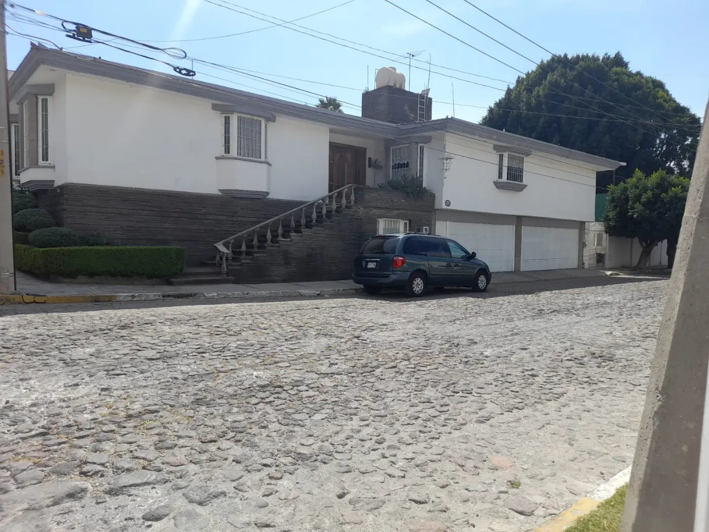 Frente de la casa, con su escalinata de balaustres subiendo a la puerta principal.
