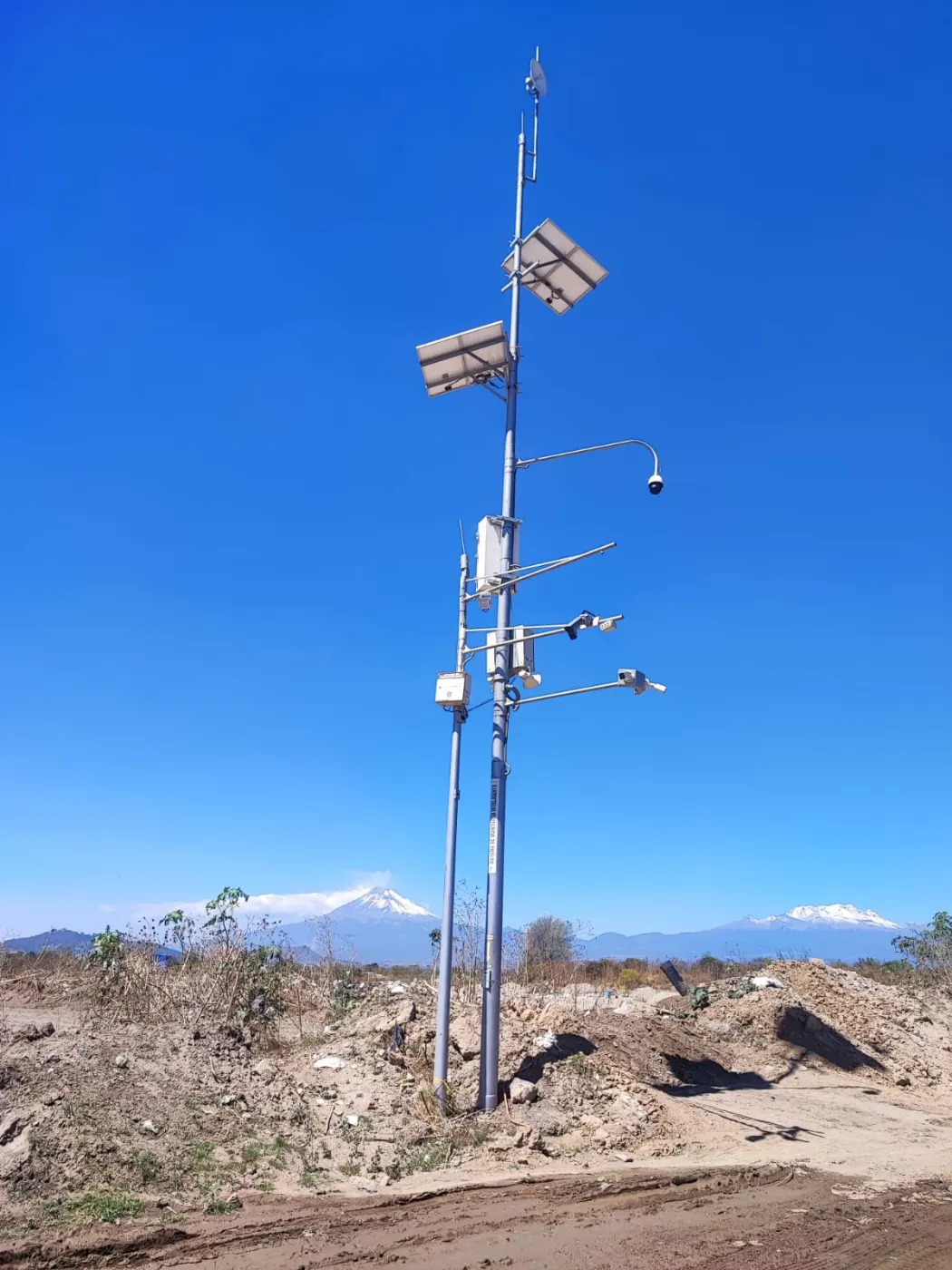 Poste de instrumentos en la linde del terreno, con el volcán al fondo.
