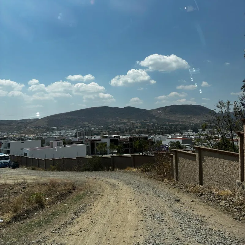 Camino de terracería que bordea la reserva territorial, con el valle de Angelópolis y los cerros al fondo.
